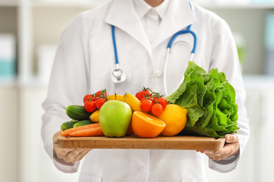 doctor holding tray of fruits and vegetables