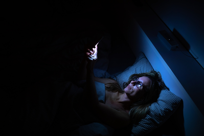 woman looking at her phone at night